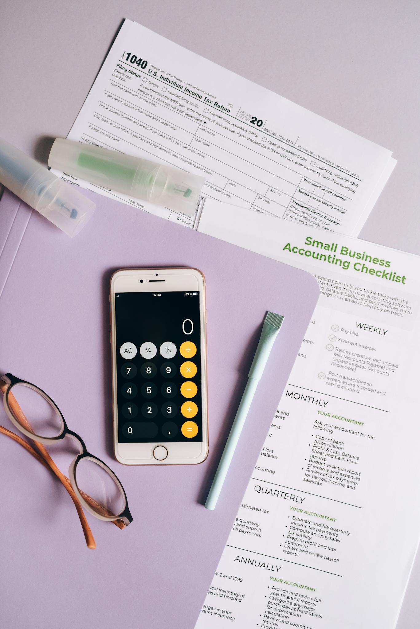 Top view of office desk with tax forms, calculator, and accounting tools.